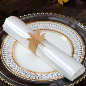 Close-up of brown paper maple leaf napkin ring on white satin napkin for table decor