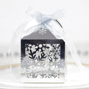 Boîte cadeau argentée avec motif de flocons de neige ajouré et un nœud en soie chic