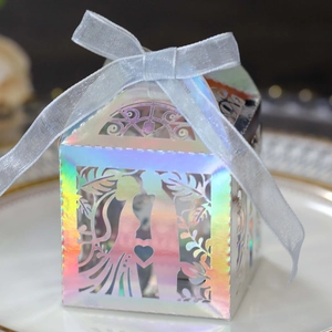 Macro shot of laser-cut wedding favor box with iridescent finish and ribbon bow
