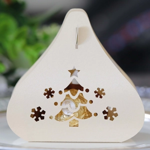 Detail of laser-cut Christmas tree and snowflake patterns on a cream favor box