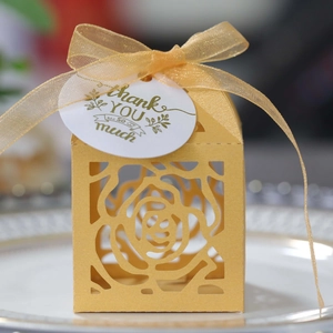 Laser-cut yellow gift box with rose pattern, gold ribbon and Thank You tag on a plate