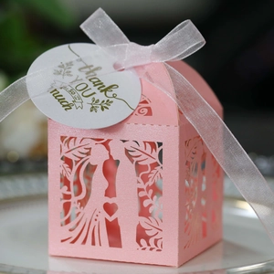 Detailed laser-cut pink wedding favor box with bride and groom silhouette and ribbon