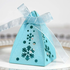 Detail van lichtblauwe geschenkdoos met lasergesneden sneeuwvlokken en glanzend striklint