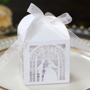 Close-up of white laser-cut wedding candy box with bride and groom silhouette
