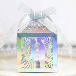Detail of laser-cut wedding candy box with holographic finish and romantic silhouettes