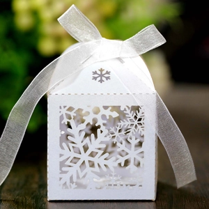 Detailed laser-cut white gift box with snowflake patterns and a sheer ribbon bow