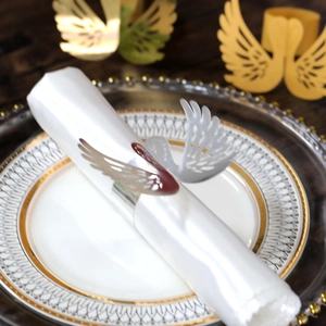Detailed laser-cut white swan napkin ring with intricate feather cutout details on a napkin