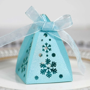 Detail van lichtblauwe piramide geschenkdoos met hol sneeuwvlokpatroon en striklint