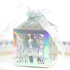 Close-up of holographic silver laser-cut wedding favor box with bride and groom silhouette