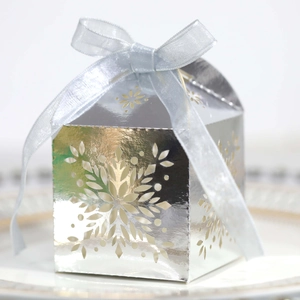 Close-up of laser-cut snowflake hollow pattern on silver mirror cardstock candy box