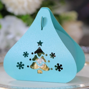 Detail of laser-cut Christmas tree and snowflake patterns on light blue gift box
