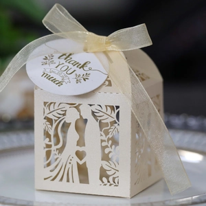 Detail of laser-cut wedding favor box with bride and groom silhouette and thank you tag