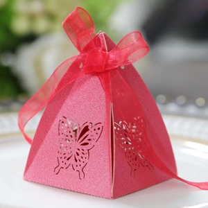 Close-up of pink pyramid candy box featuring laser-cut butterfly and red ribbon bow