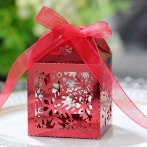 Gros plan de la boîte cadeau rouge de Noël avec motifs de flocons et ruban de soie