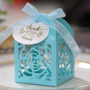 Detail of light blue laser-cut rose gift box with silk ribbon and thank you tag