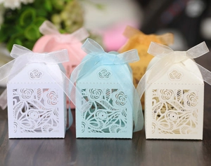 Detail of laser-cut floral paper gift boxes with elegant silk ribbons in multiple colors