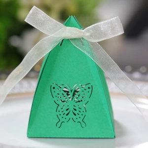 Macro shot of mint green pyramid candy box with butterfly laser-cut and white ribbon