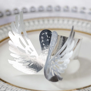 Macro shot of silver swan napkin ring with laser-cut hollow details on white ceramic plate