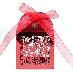 Détail de la boîte cadeau rouge en forme de maison avec flocons découpés au laser