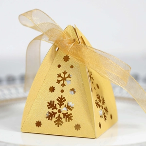 Gedetailleerde weergave van gouden piramide geschenkdoos met sneeuwvlokken