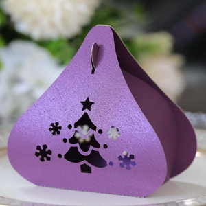 Close-up of purple pearlescent triangle gift box with laser-cut Christmas tree and snowflake