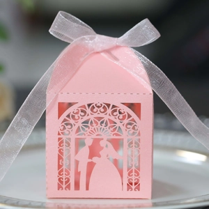 Pink laser-cut wedding favor box with bride groom silhouettes and a white ribbon bow