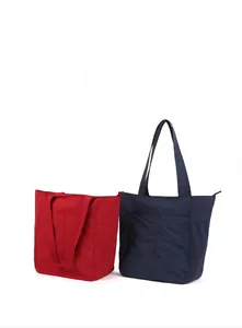 Vista frontale di grandi borse tote rosse e blu navy con tasche esterne funzionali