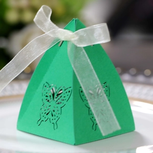 Detailed view of green pyramid candy box with hollow butterfly design and white ribbon