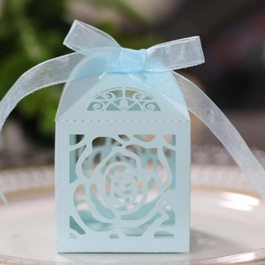 Close-up of light blue laser-cut candy box with rose pattern and matching ribbon