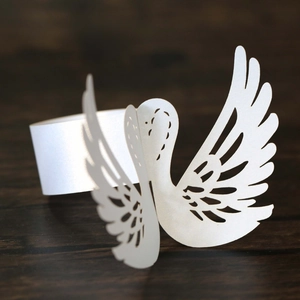 Macro view of laser-cut swan napkin ring made of elegant white pearlescent paper