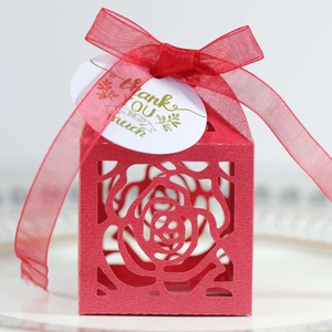 Close-up of red laser-cut rose candy box with organza ribbon and white thank you tag