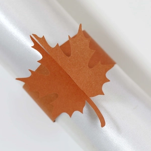 Macro shot of laser-cut red maple leaf napkin ring with shimmering pearlescent finish
