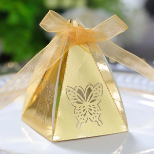Macro detail of golden hollow butterfly wedding candy box with elegant ribbon bow decoration
