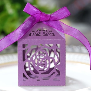 Close-up of purple laser-cut rose paper candy box with elegant silk ribbon bow