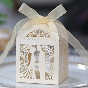 Laser-cut wedding favor box with bride and groom silhouette and cream organza ribbon