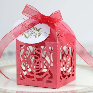 Macro shot of red laser-cut rose gift box with silk ribbon and Thank You tag