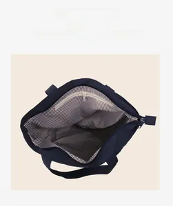 Dettaglio della borsa tote blu con fodera a righe e tasca interna con cerniera