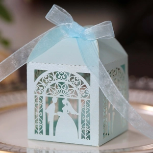 Macro view of light blue wedding favor box with laser-cut bride and groom silhouette