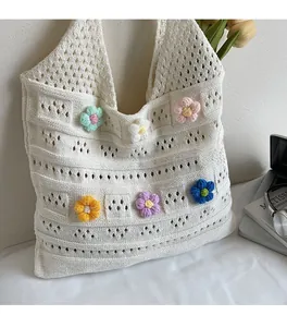 Detail of 3D crochet flowers on a beige knit tote bag with aesthetic lifestyle props