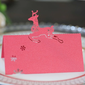 Laser cut reindeer place cards in red pearlescent paper for Christmas table settings
