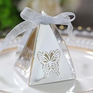 Macro shot of silver hollow butterfly candy box with pyramid shape and white ribbon bow