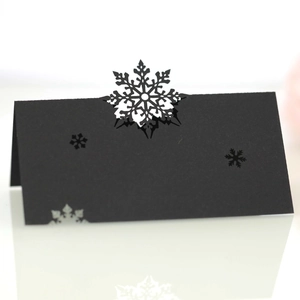 Detailed laser-cut snowflake wedding place cards in black cardstock for table setting