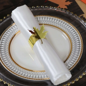 Golden maple leaf napkin ring on white satin napkin for elegant fall table decor