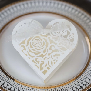 Detail showing white heart gift box with laser-cut rose patterns and elegant white ribbon