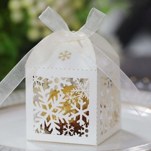 Elegant white laser-cut snowflake wedding favor box with a delicate white organza ribbon