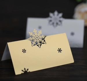 Detail of laser-cut snowflake place cards in gold and white pearlescent paper