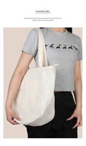 Dettaglio della grande borsa tote bianco panna con tracolla larga e chiusura a zip