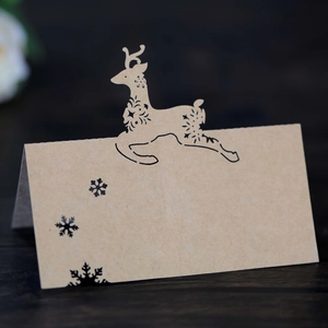 Macro shot of laser-cut reindeer kraft paper place cards with black snowflake pattern