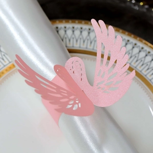 Detail of pink swan laser-cut napkin ring with glitter finish on a white satin napkin