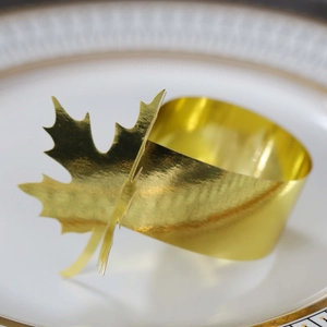 Macro shot of a golden maple leaf napkin ring placed on a premium white porcelain plate